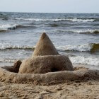 Zandkasteel en zandsculptuur op het strand