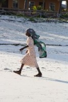Een jongedame aan de wandel op het strand